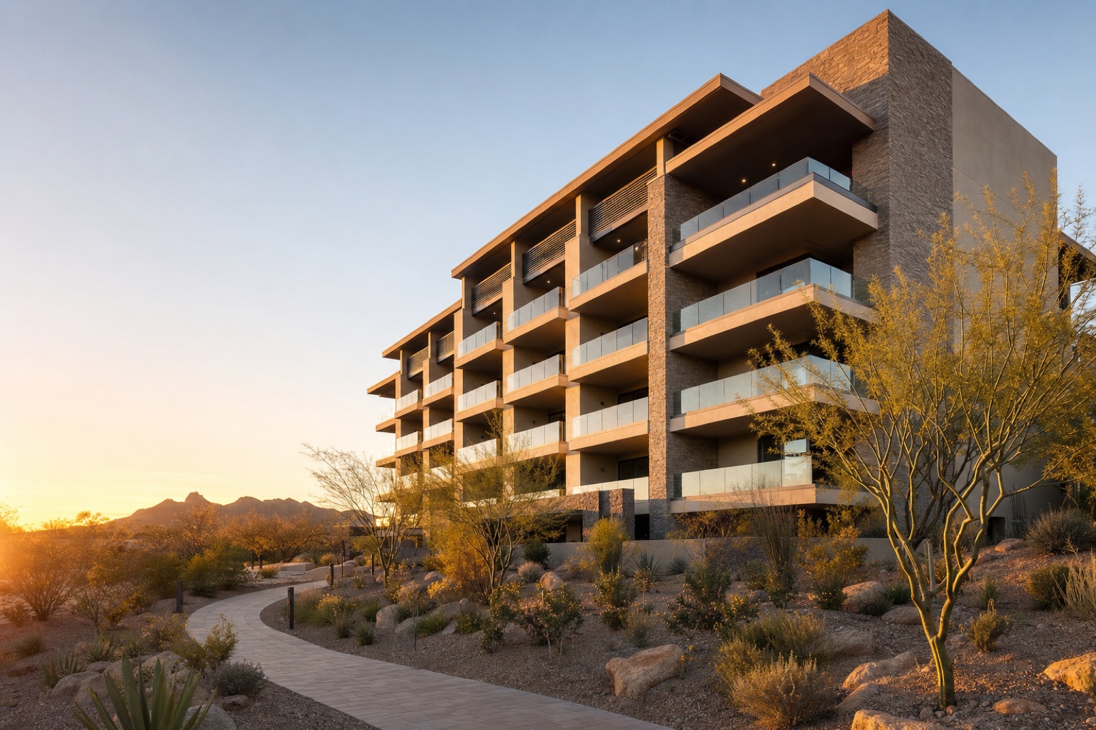 A five-story desert-modern condominium building at golden hour